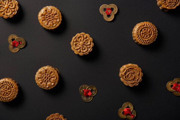 top view of traditional mooncakes and feng shui coins isolated on black