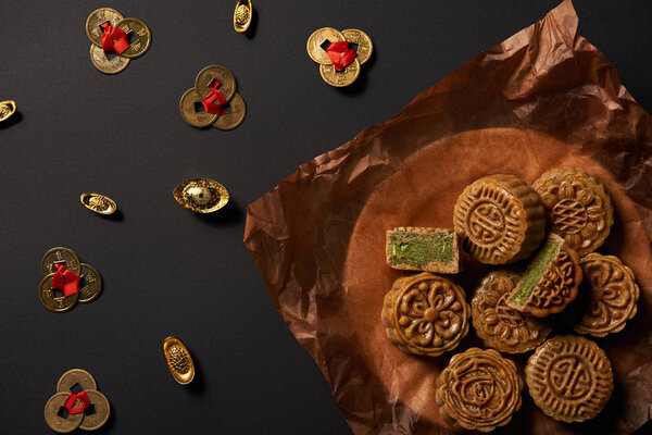 top view of mooncakes with feng shui coins isolated on black