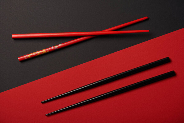 top view of two sets of chopsticks on red and black background