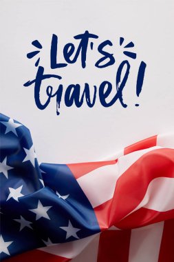 top view of united states of america flag and lets travel lettering on white surface  clipart