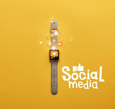 smartwatch kutsal kişilerin resmi ve sosyal medya yazı sarı yüzeyi ile üstten görünüm 