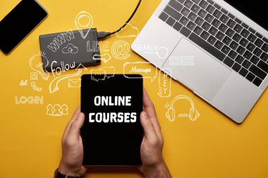 cropped view of man holding digital tablet with online courses illustration  clipart