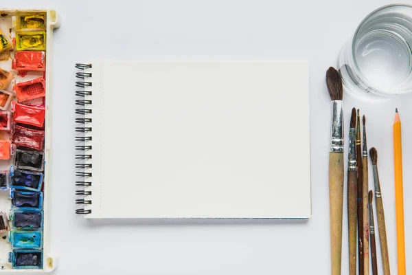 白い背景の水彩絵の具と絵筆でアルバムのトップ ビュー — ストック写真