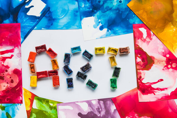 вид сверху на акварельные абстрактные рисунки и надписи из красок
