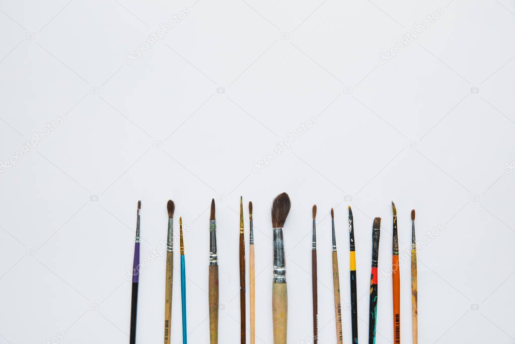 top view of white background with paint brushes placed horizontally