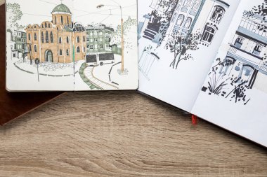 top view of drawings in albums on wooden background clipart