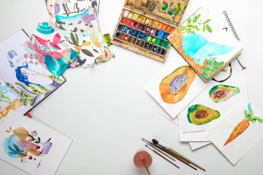 top view of multicolored watercolor paintings and drawing utensils clipart