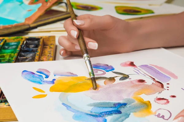 水彩颜料和画笔在纸上绘制女性手绘的选择性焦点 — 图库照片