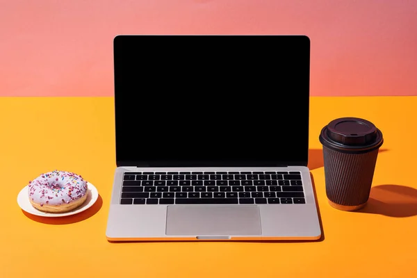 도넛과 노트북 노란색 분홍색 배경에 — 스톡 사진