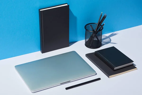 Laptop Μολυβοθήκη Και Σημειωματαρίων Λευκή Επιφάνεια Και Μπλε Φόντο — Φωτογραφία Αρχείου