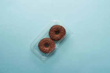 mavi zemin üzerine lezzetli çikolatalı Donuts üstten görünüm 