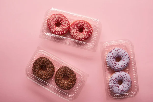 在粉红色背景上的美味甜甜圈的顶部视图 — 图库照片
