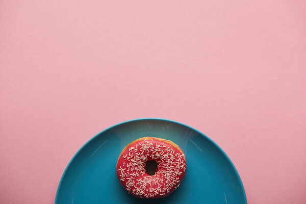 вид сверху на вкусный пончик на голубой тарелке изолирован на розовый
 