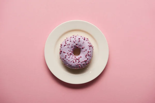 Κάτοψη Του Νόστιμο Ντόνατ Στο Άσπρο Πιάτο Ροζ Φόντο — Φωτογραφία Αρχείου