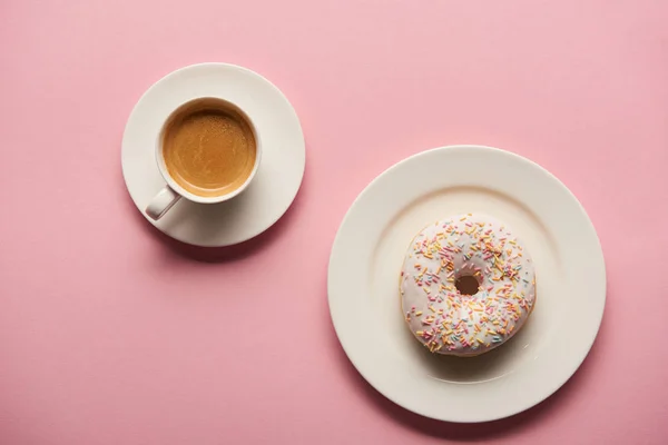 甜釉面甜甜圈附近的杯子咖啡在粉红色的背景的顶视图 — 图库照片