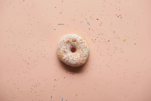在粉红色背景上的甜釉面甜甜圈的顶视图 — 图库照片