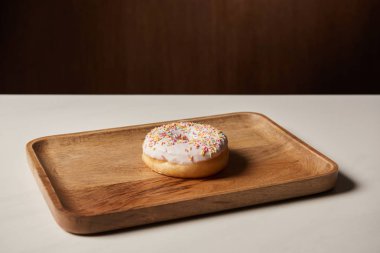 Ahşap kesme tahtası üzerinde sprinkles ile lezzetli çörek 