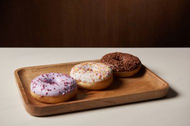 Ahşap kesme tahtası üzerinde sprinkles ile lezzetli çörekler