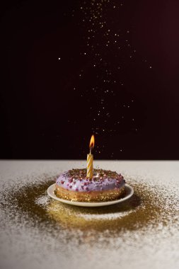 yanan mum ile düşen parıldıyor üzerine siyah izole lezzetli donut ortada