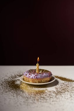 beyaz masa üstünde siyah izole üzerinde parlak parıldıyor ile tatlı çörek ortasına mum