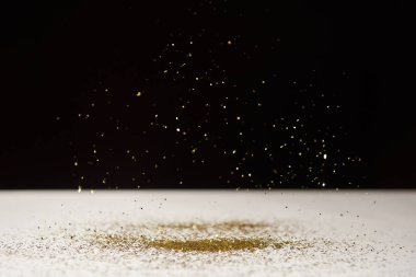 selective focus of white table with bright sparkles isolated on black 