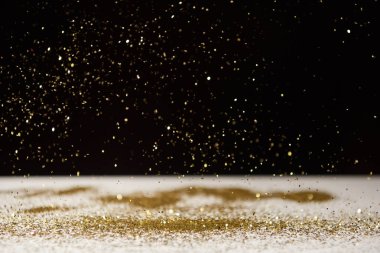seçici odak parlak sparkles beyaz masa üstünde siyah izole düşüyor 