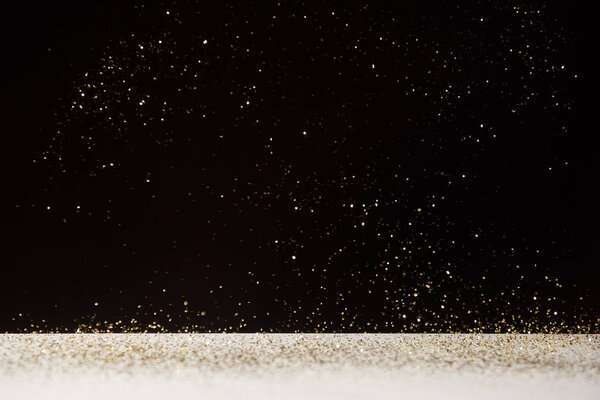 white table with bright shiny sparkles isolated on black 
