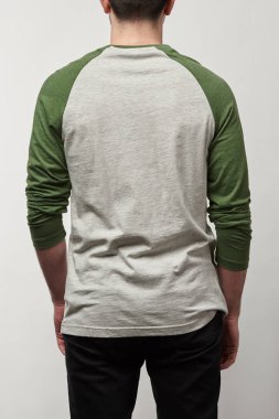 back view of man in raglan sleeve baseball shirt with copy space isolated on grey clipart