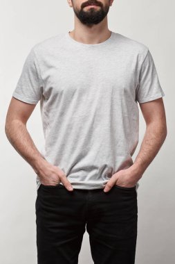 sakallı adam beyaz t-shirt gri izole kopya alanı ile ceplerinde elleriyle kırpılmış görünümünü