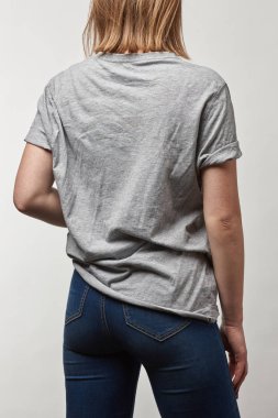 Arkadan Görünüş temel gri t-shirt genç kadının üzerinde beyaz izole kopya alanı ile