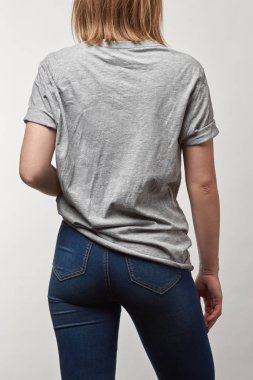 Arkadan Görünüş temel gri t-shirt genç kadının üzerinde beyaz izole kopya alanı ile