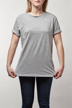 Gri t-shirt üzerinde beyaz izole kopya alanı ile genç kadının kırpılmış görünümü