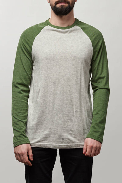 partial view of man in basic raglan sleeve baseball shirt with copy space isolated on grey