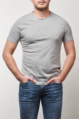 kısmi t-shirt ceplerinde gri izole kopya alanı ile elinde olan adam görünümünü