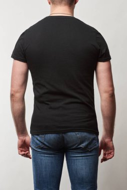 arkadan görünüşü adam denim ve siyah t-shirt gri izole kopya alanı ile