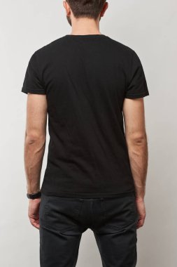back view of man in black t-shirt with copy space isolated on grey clipart