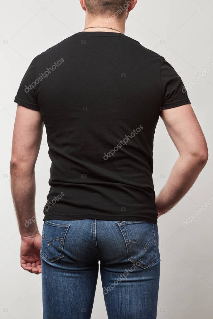 Back view of man in black t-shirt with copy space isolated on grey