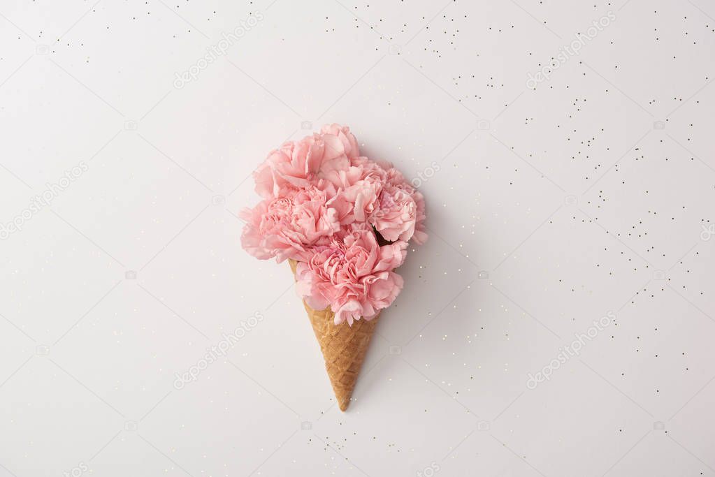 beautiful pink carnation flowers in waffle cone isolated on grey