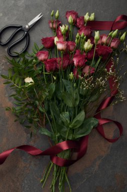 güzel kırmızı eustoma şerit ve makas karanlık yüzeyindeki çiçeklerle 