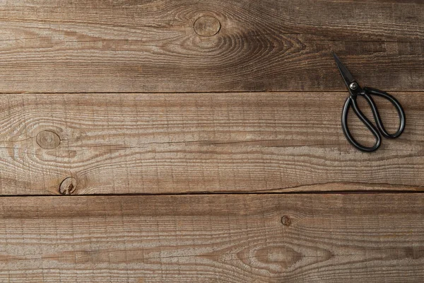 茶色の素朴な木製の背景にはさみのトップ ビュー — ストック写真