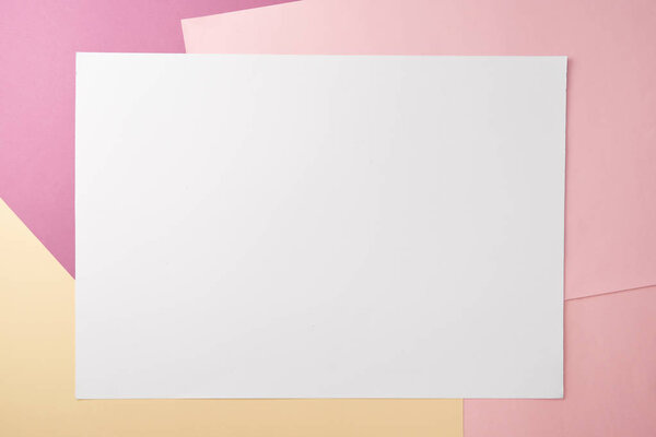 top view of blank white card and empty colored paper background