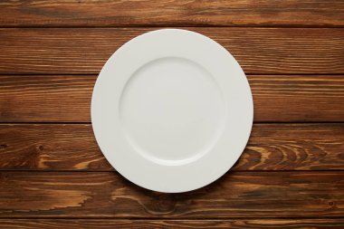 top view of white empty plate on wooden background clipart