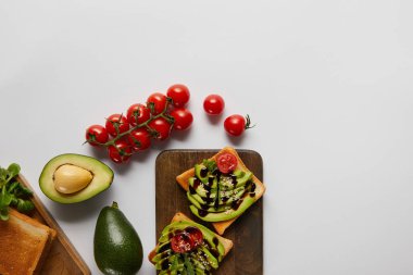 tost üstten görünüm avokado ve gri backgroud kiraz domates ile ahşap kesme tahtaları üzerinde