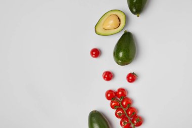 gri arka plan üzerinde avokado ve kiraz domates üstten görünüm