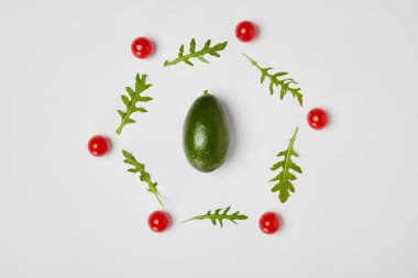 gri arka plan üzerinde avokado, arugulas yaprakları ve kiraz domates üstten görünüm