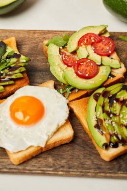 tost ile çırpılmış yumurta, domates ve avokado ahşap arka plan üzerinde seçici odak