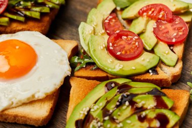 tost ile çırpılmış yumurta, domates ve avokado ahşap arka plan üzerinde seçici odak