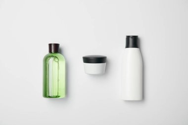 Top view of different cosmetic bottles on white background clipart