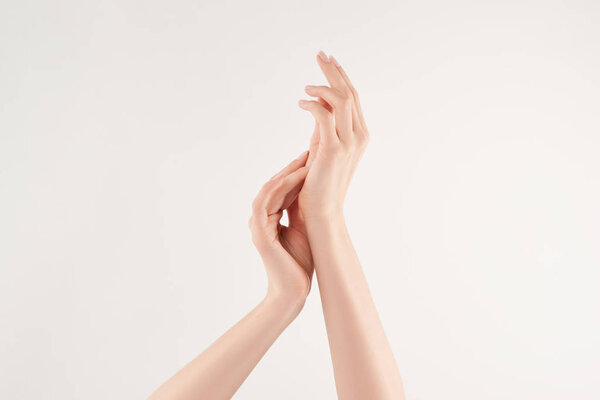 Partial view of woman applying cosmetic cream on white background
