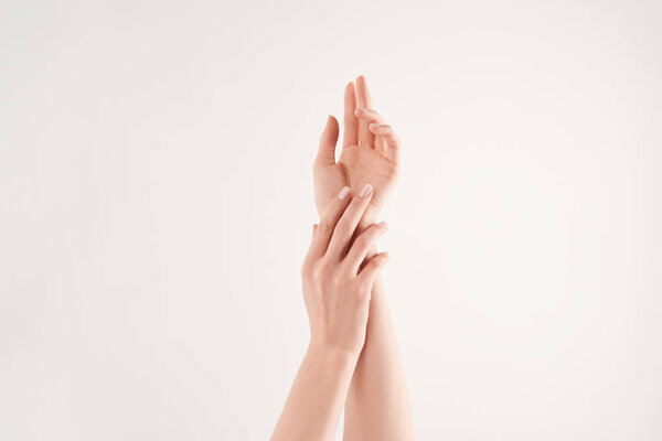 Partial view of well-cared female hands on white background